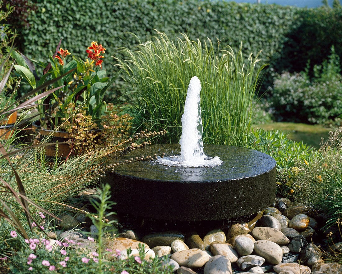 Garten-Brunnen mit Muehlstein als Springbrunnen